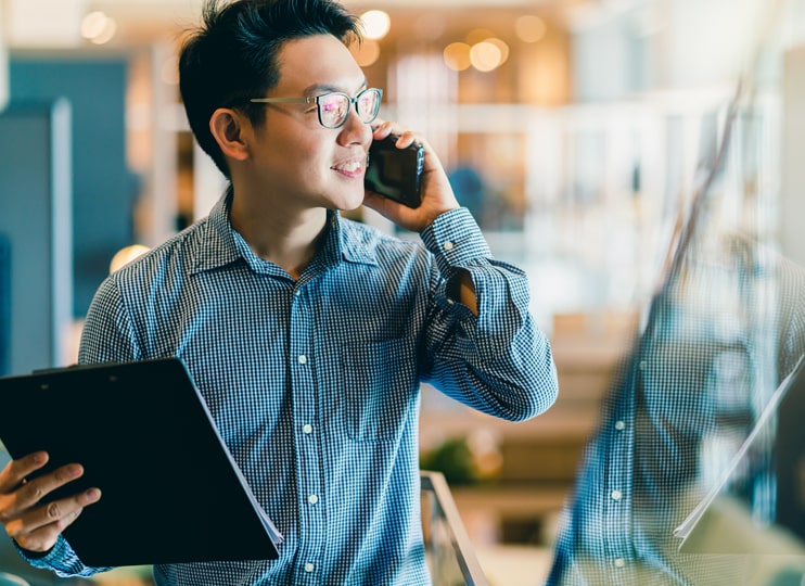 Man on the phone holding a clipboard