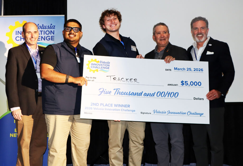 Group photo with representatives from Economic Development organizations and the 2nd place winners holding the big check for $5,000 for their innovative product Tracker.